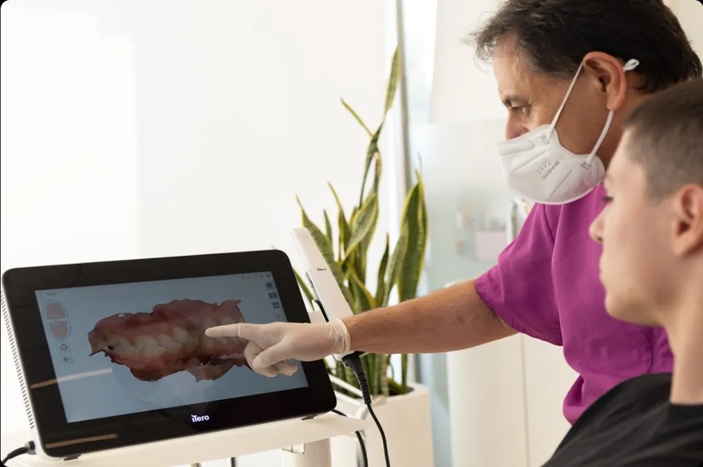 Ο Dr. Τσαγιάννης δείχνει σε ασθενή ψηφιακή 3D αποτύπωση στον σαρωτή iTero